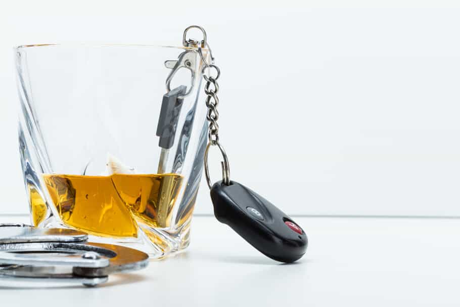 Keys and Cuffs Next to Alcohol